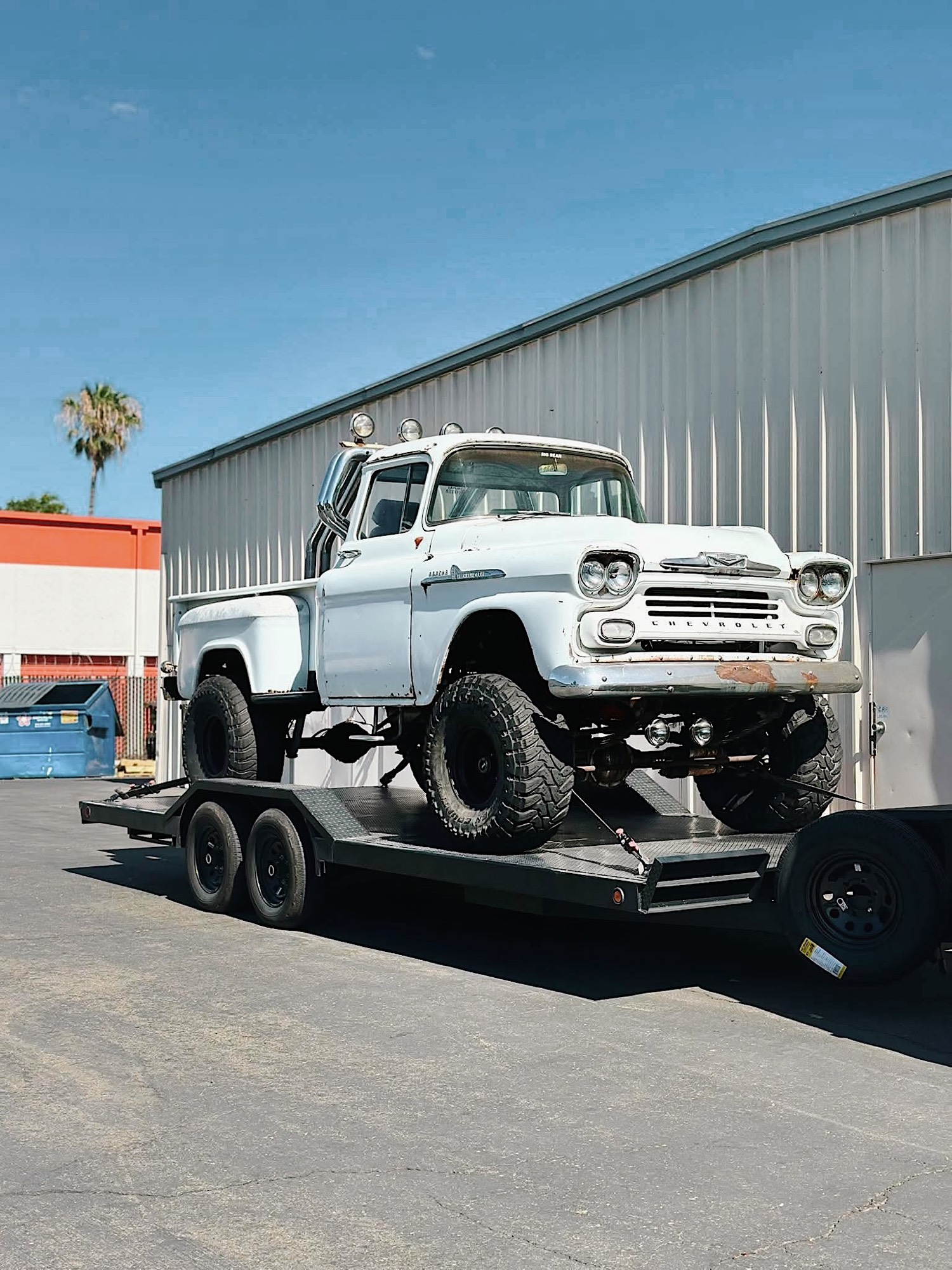 Lifted classic Chevrolet Apache pickup loaded and strapped on the 412 trailer